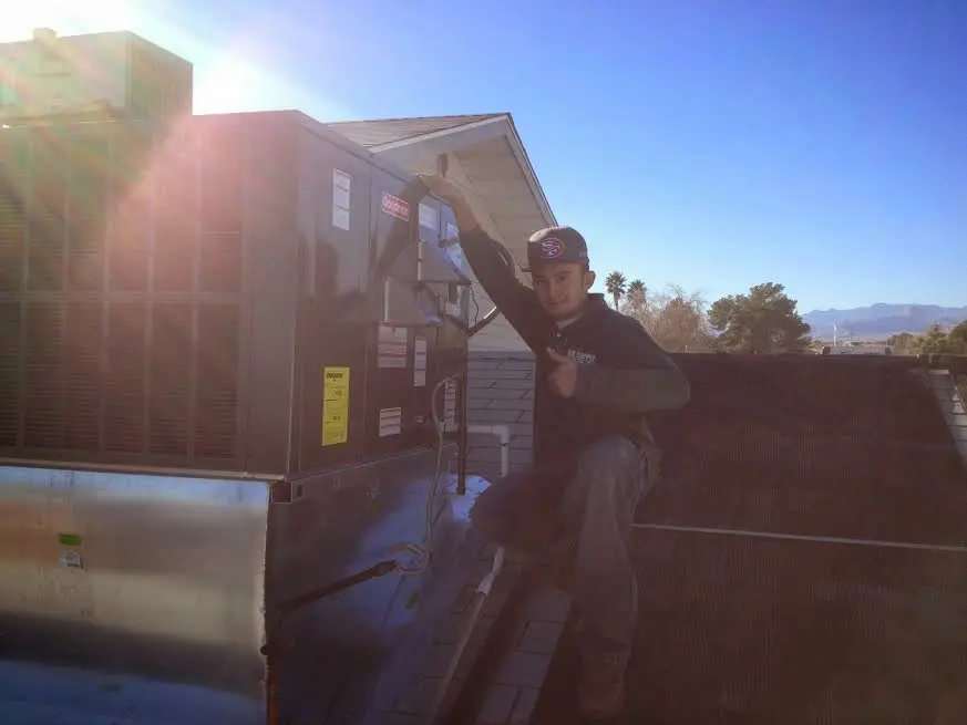 HVAC technician performing Air Duct Repair on a rooftop unit in Wedgefield
